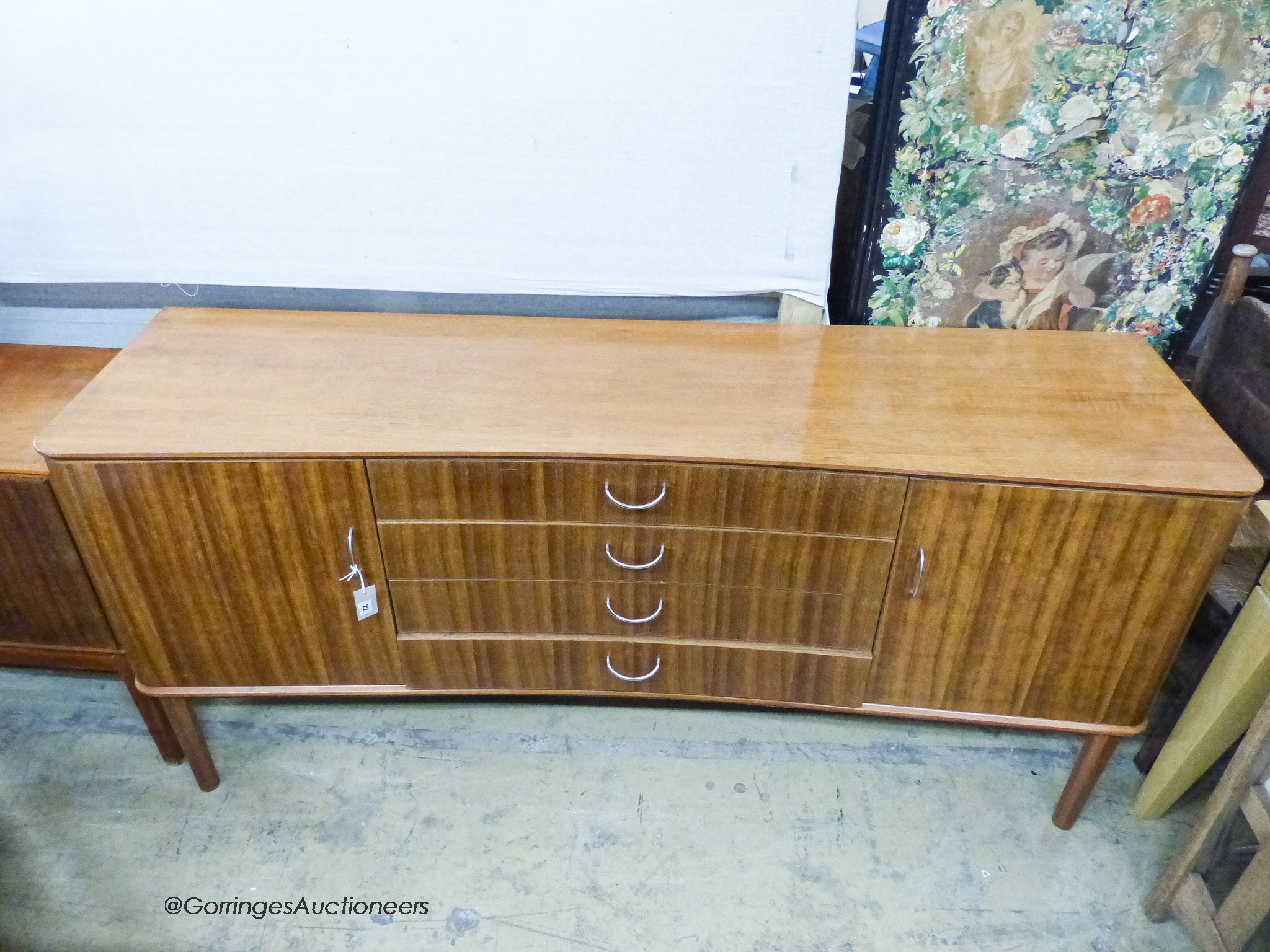 A Gordon Russell Ltd teak and Indian Laurel concave sideboard Model R810 circa 1960, length 183cm, depth 49cm, height 86cm